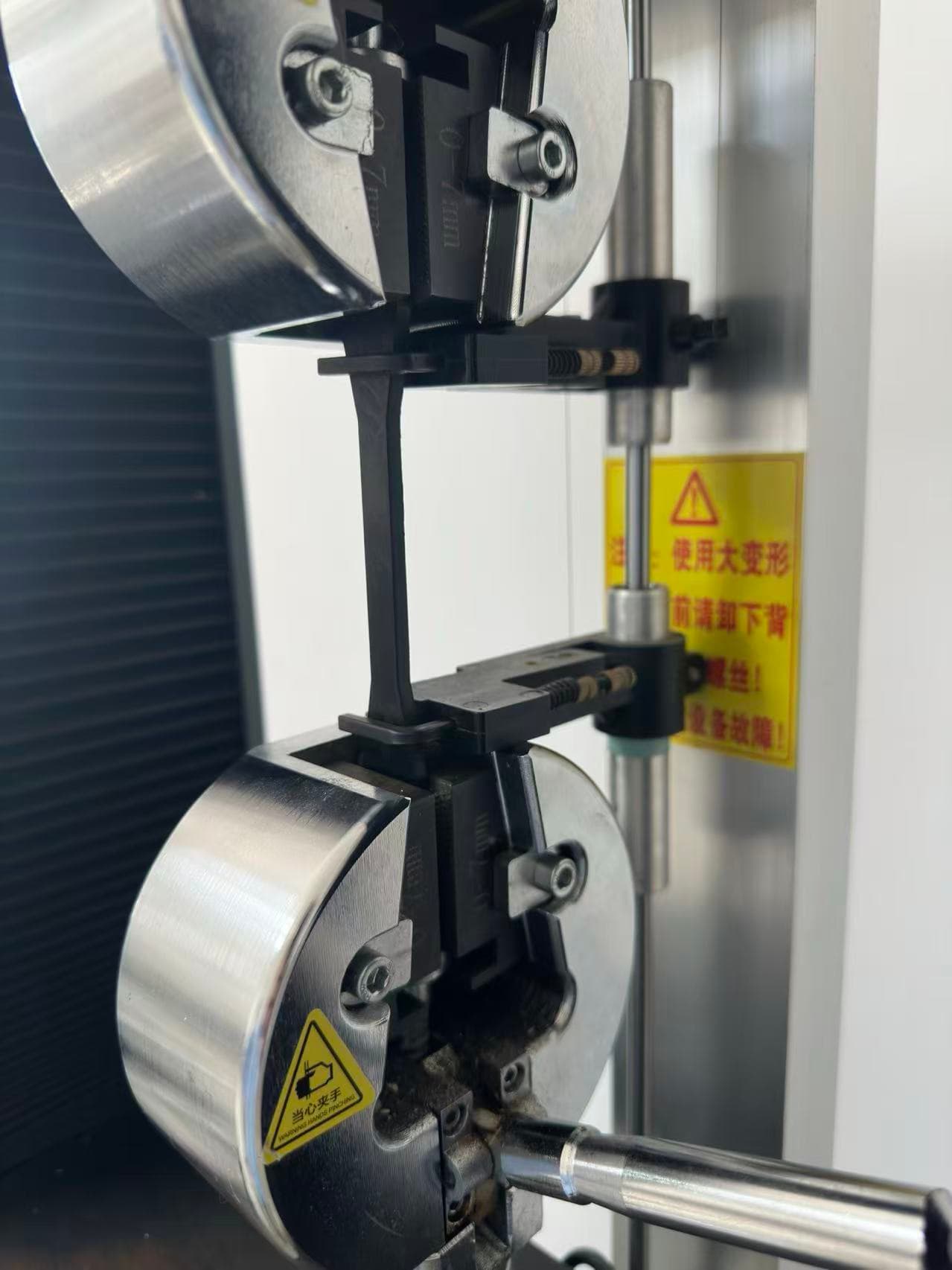 Taiyi Polymer tensile-test specimen clamped in laboratory testing equipment